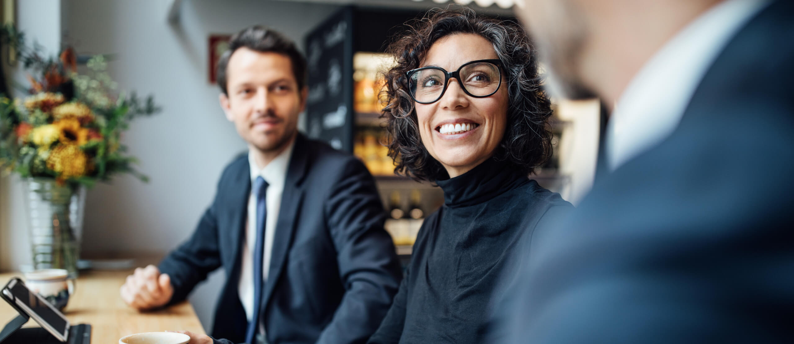 Group of three business people sitting at a coffee shop